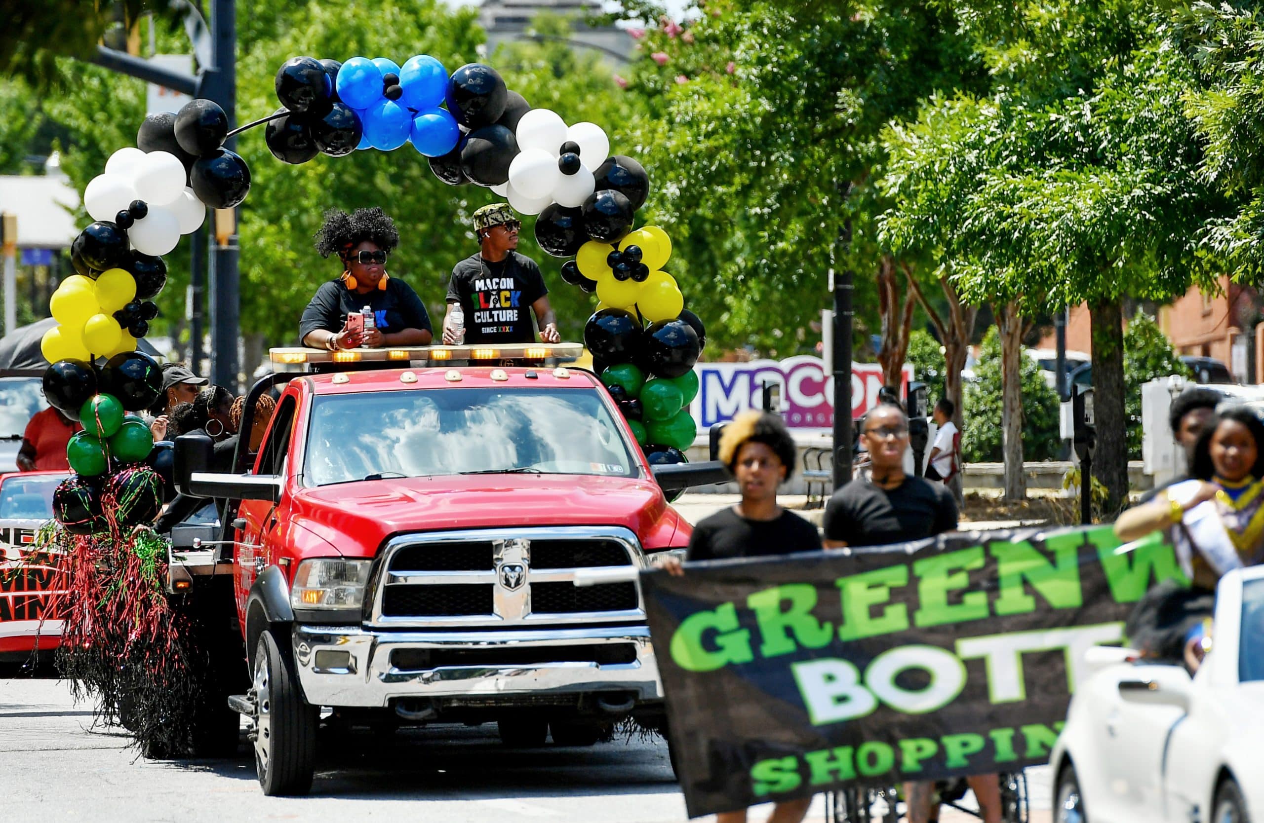 People march and ride in a truck during a Juneteenth parade.
