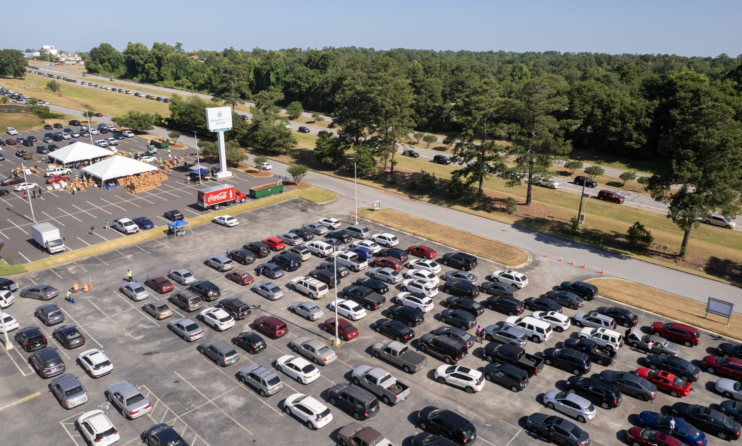 A drone photo of volunteers distributing food in a parking lot.
