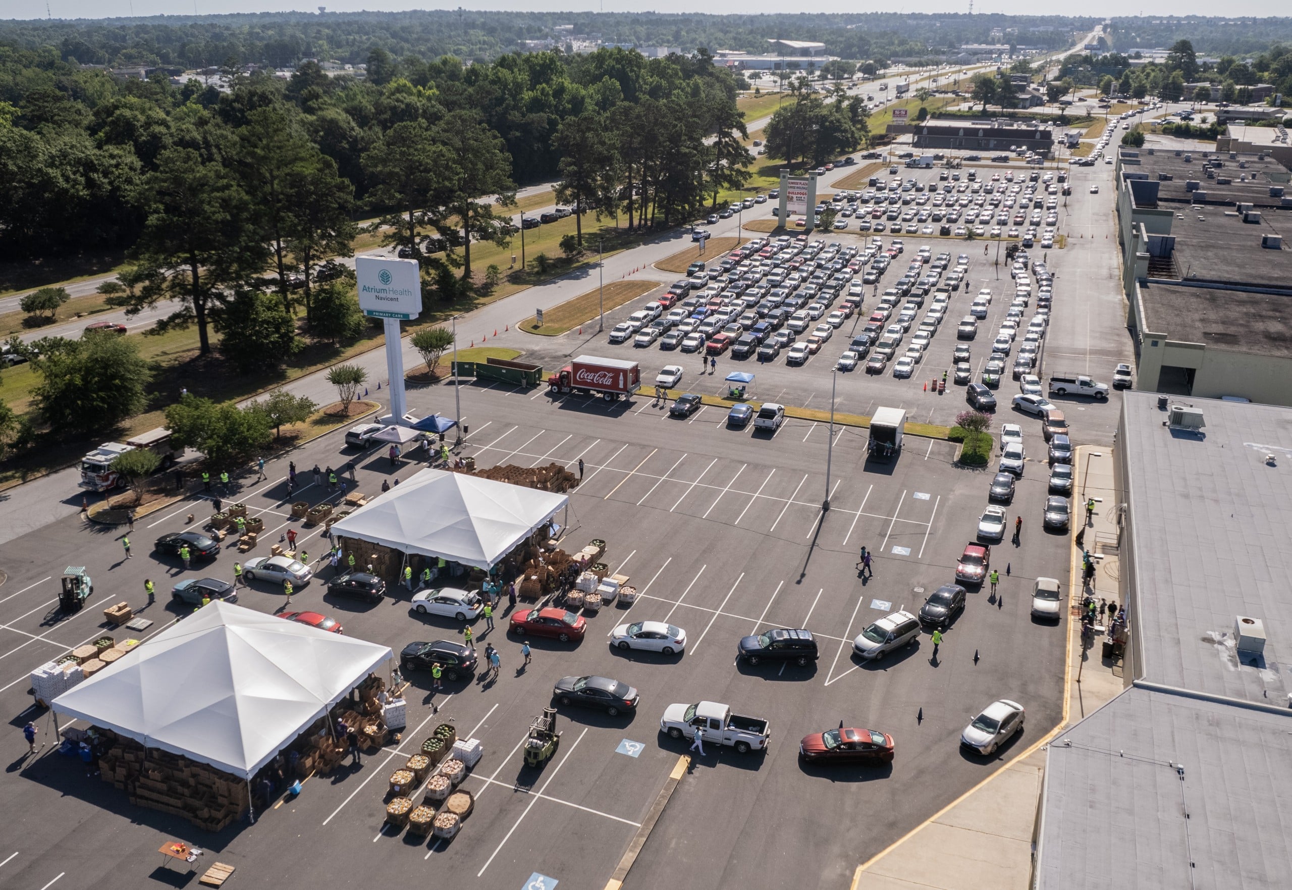 A drone photo of volunteers distributing food in a parking lot.
