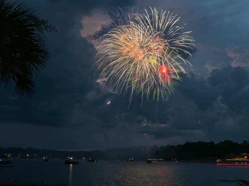 Colorful fireworks shot over Lake Tobesofkee at night.