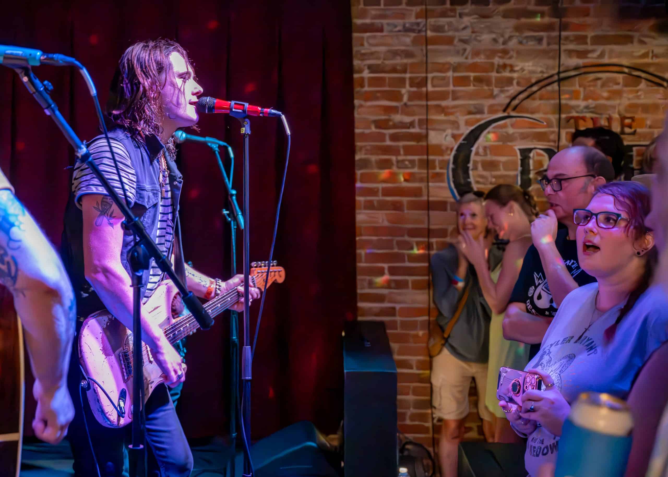 A band performs a concert on stage in front of fans
