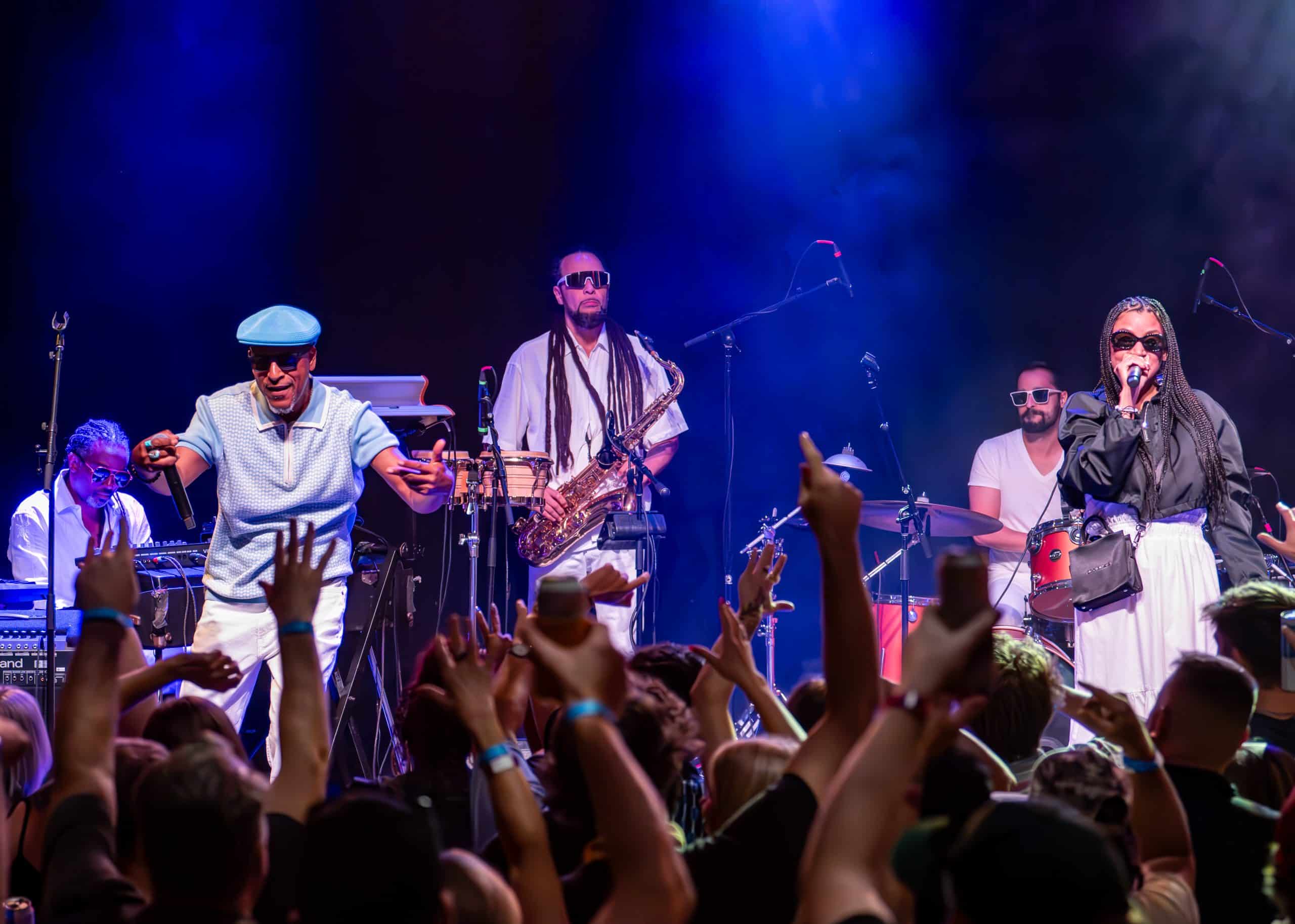 A band performs a concert on stage in front of fans