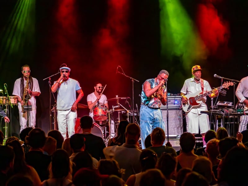 A band performs a concert on stage in front of fans.