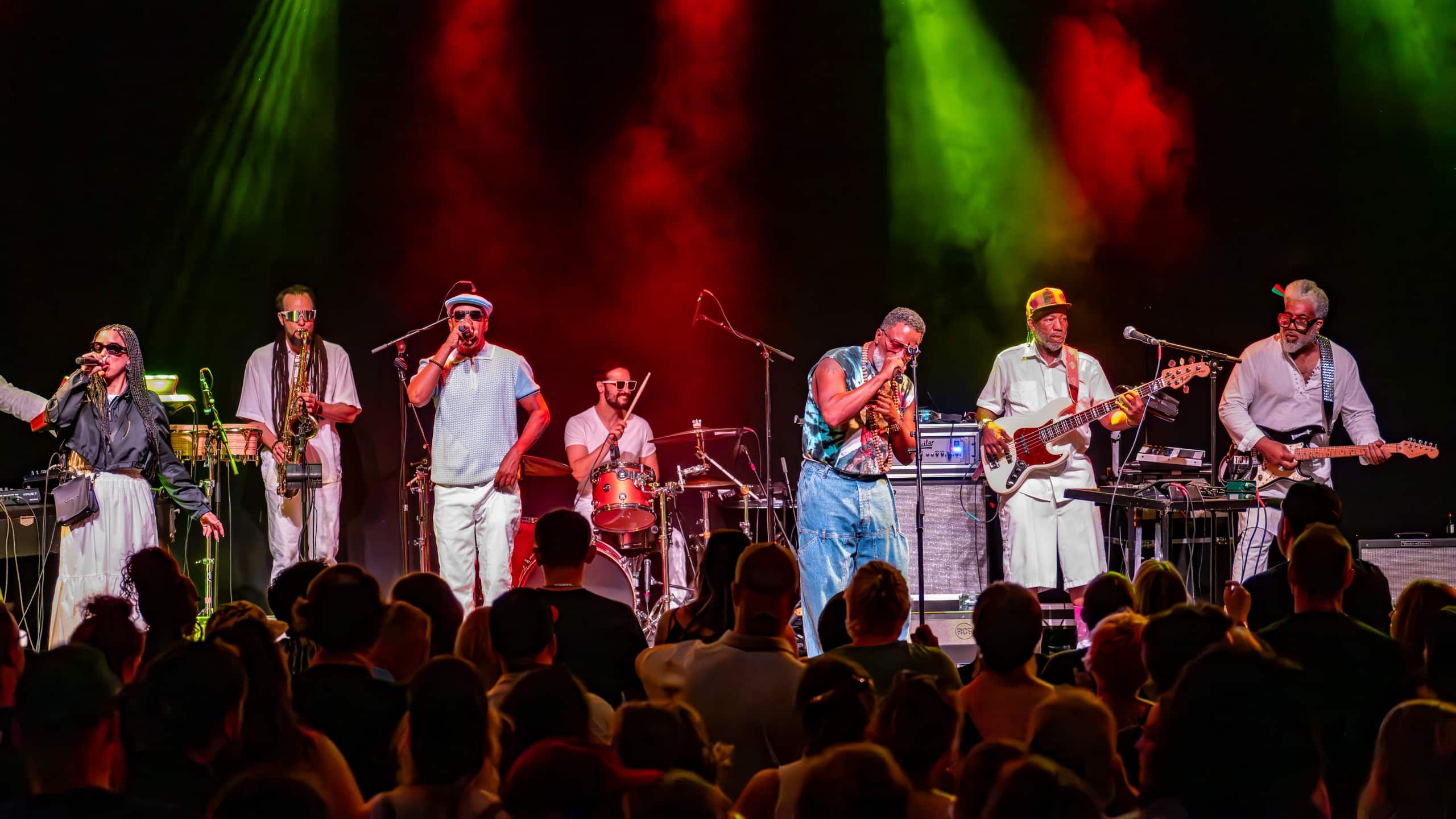 A band performs a concert on stage in front of fans.